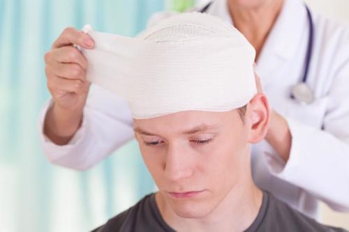 A man having a head injury suffered at work treated by a doctor.