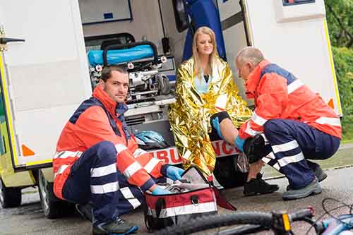 This image shows a woman being treated in an ambulance after a bicycle crash.