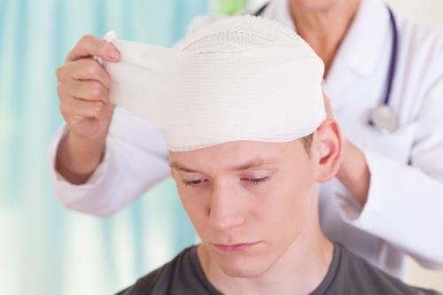 A man getting a head injury treated by a doctor.