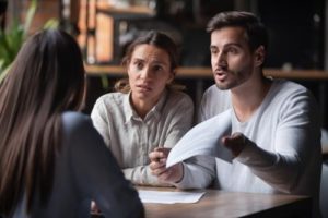 A couple meeting with a Brookhaven personal injury lawyer to file a claim.