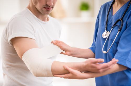 A man getting medical treatment for an elbow injury he suffered in a pedestrian accident.