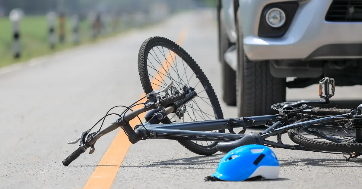 Bicycle on the ground after being hit by a car