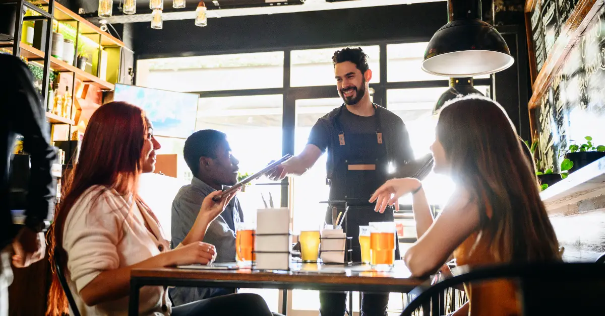 Waiter at a restaurant handing menus to guests
