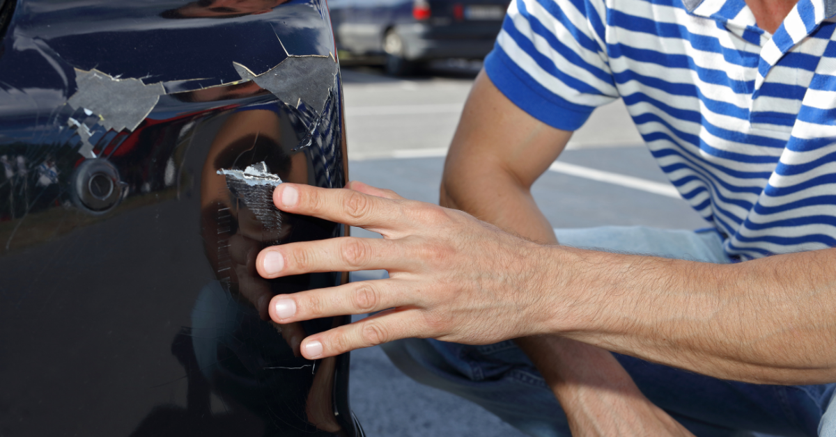 inspecting a scratch on a car bumper