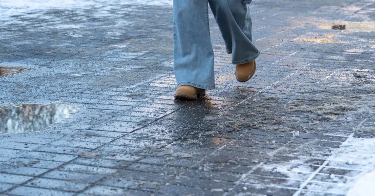 Woman walking on an icy sidewalk at risk of a slip and fall accident
