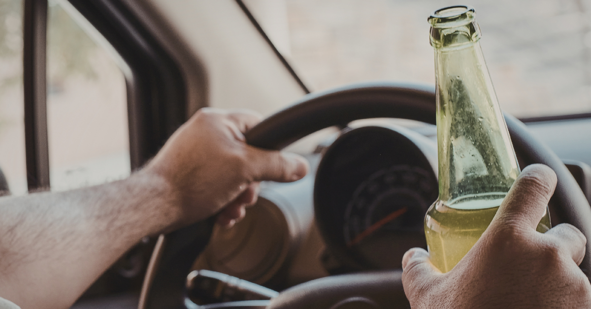 A person engaging in drinking while operating their car,