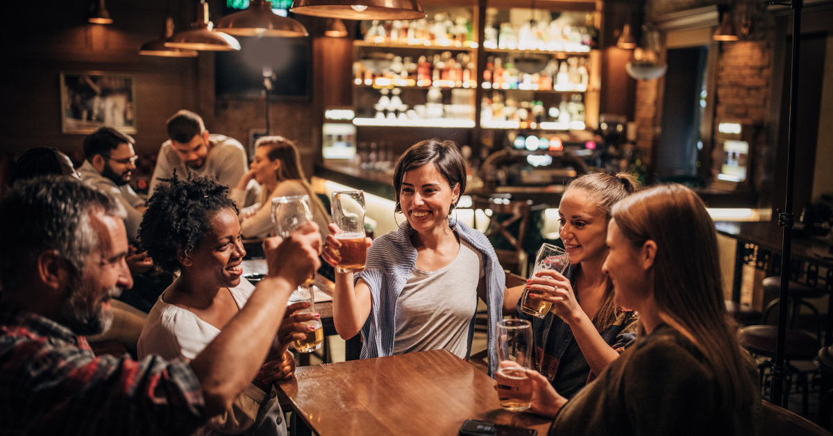 Group of adults drinking alcohol at a bar, illustrating circumstances that may relate to a New York drunk driving accident