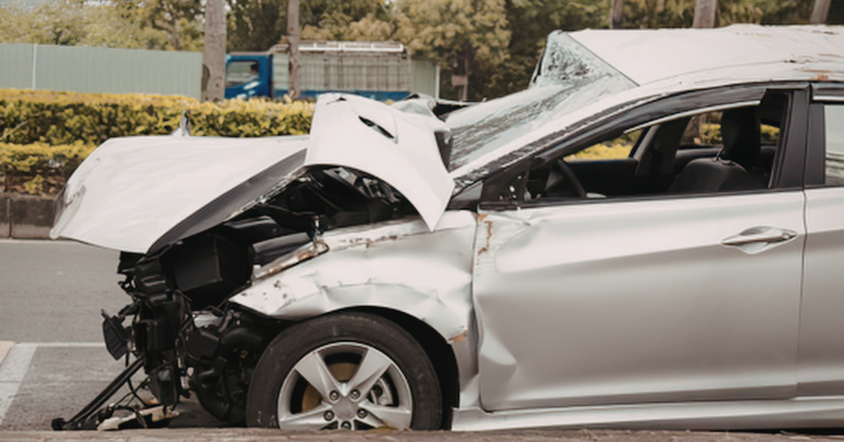Front-end damage to a car after a car crash, showing a smashed hood and impact to the front of the vehicle.