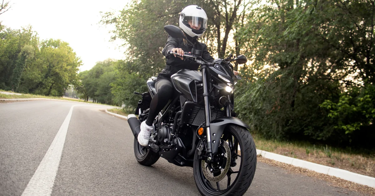 Young woman riding a motorcycle down a road