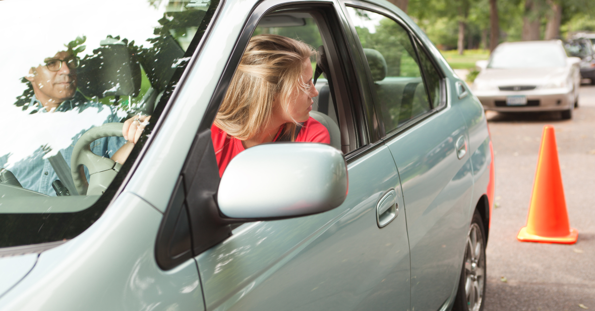 Teen Driver looking behind her out of the window.