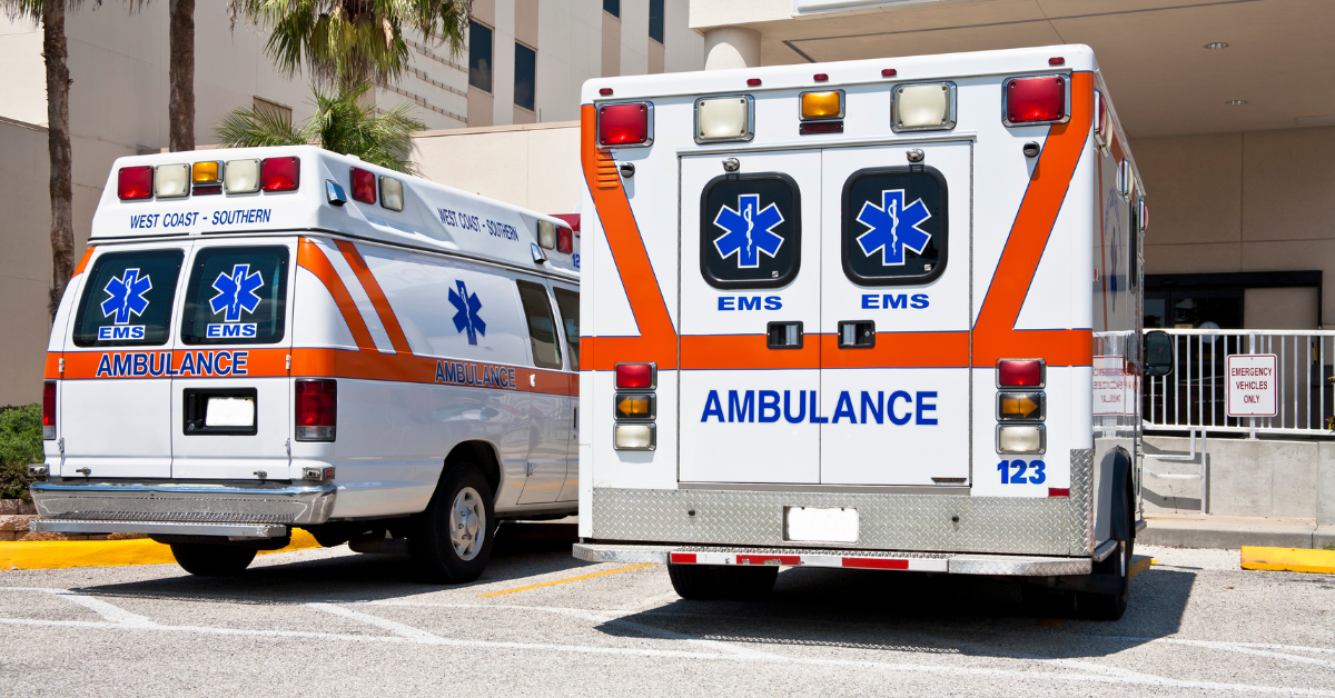 Two ambulances parked outside of a hospital.