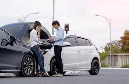 A woman and man exchanging contact information after a car accident in Brooklyn.