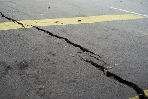 A large crack in a road, an issue that can lead to a motorcycle accident.