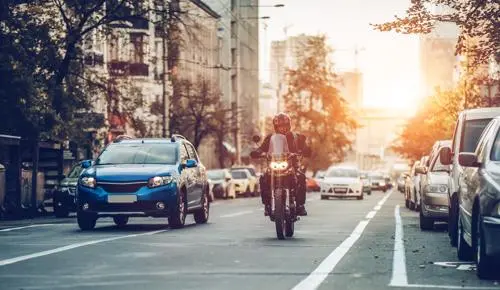 A photo of a man riding a motorcycle in a city.