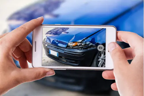 Clarkstown Car Accident Lawyer woman using a smartphone to take picture of car damaged in crash