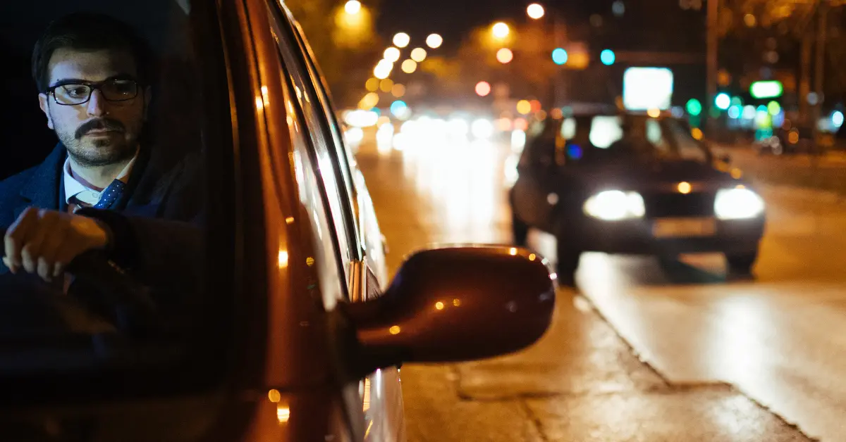 Man waiting for car to pass at night