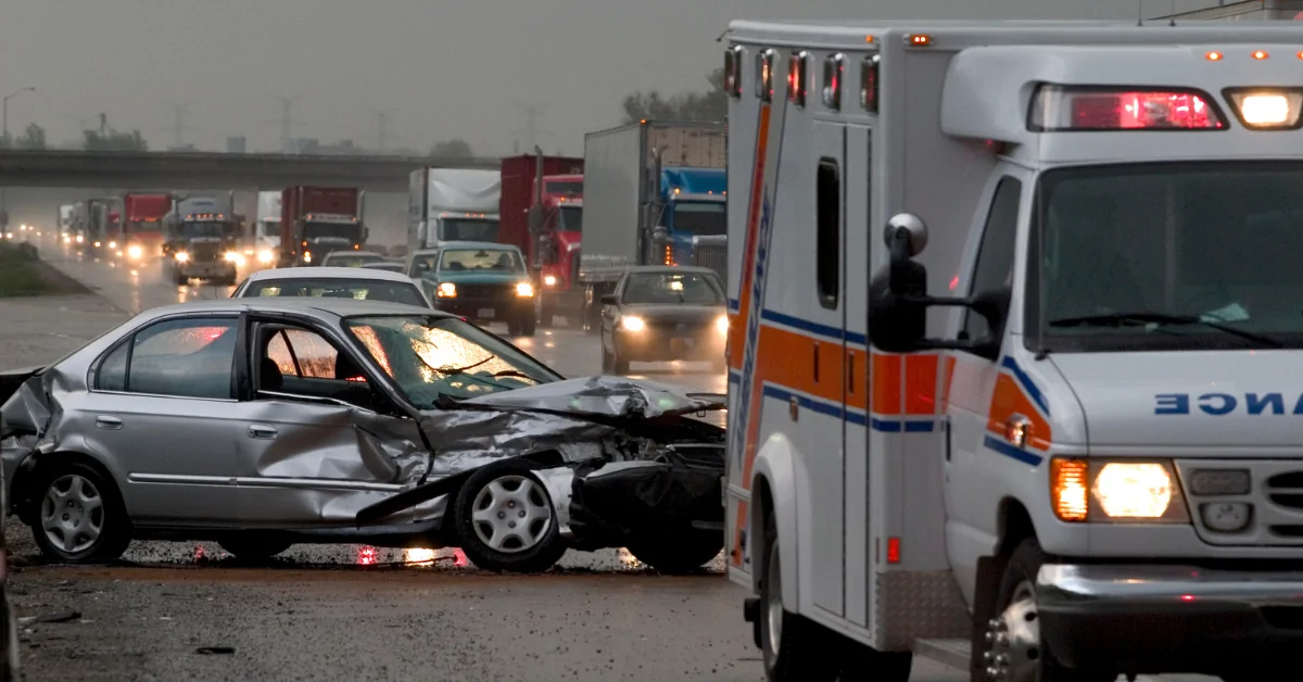 Ambulance driving away from car crash on highway