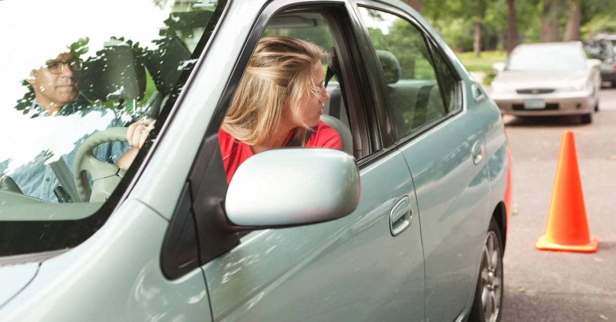 Teen Driver looking behind her out of the window.
