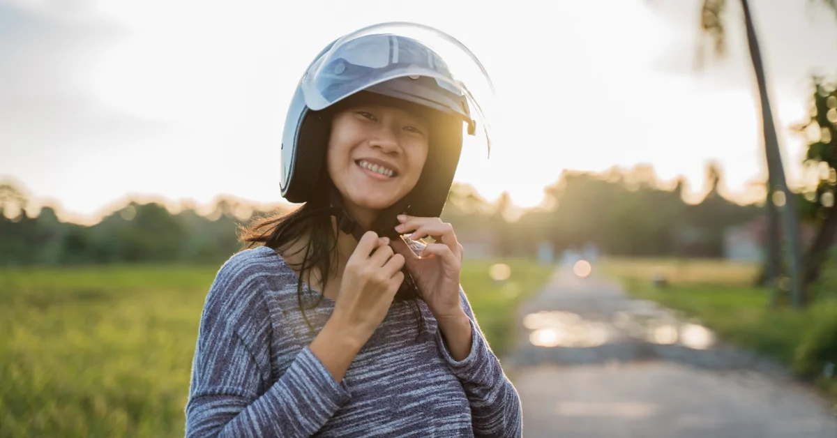 Woman putting on a helmet with visor.